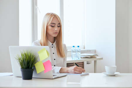 Business, business woman, girl in the office, girl working, woman at the computer, woman writing in notebook.の写真素材