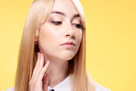Blonde, portrait, girl on yellow background, young woman.の写真素材