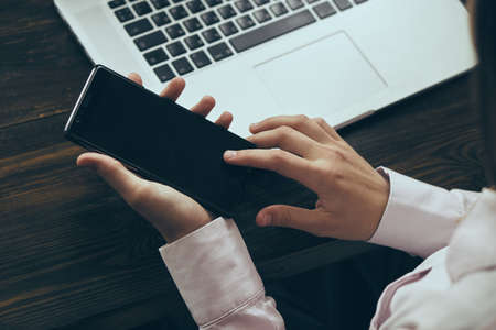 Office, work, business, phone, laptop, girl holding smartphone.の写真素材