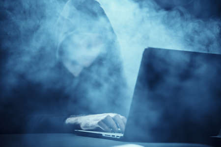 Hacker, laptop, smoke, programmer, work at the computer.の写真素材
