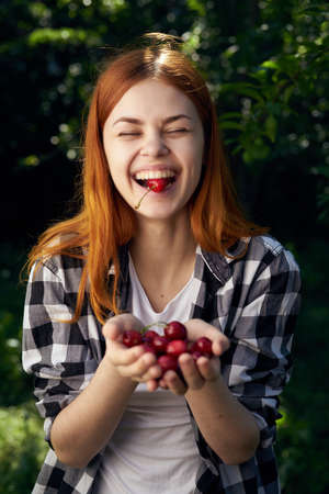 Woman with a cherry, woman with a berry, season, summer, summer residence.の写真素材