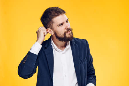 Business man thinking, business man with a beard, business man on a yellow background.の写真素材