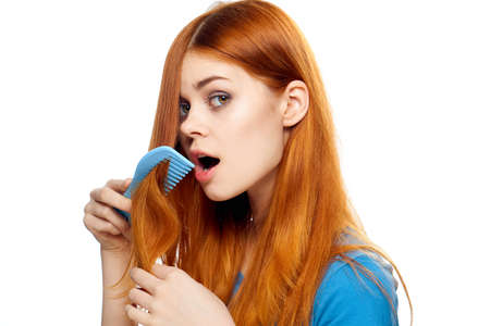 Woman combing her hair, looking after hair, woman on isolated background.の写真素材