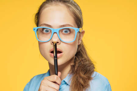 Surprised woman, woman with glasses, woman on yellow background portrai.の写真素材