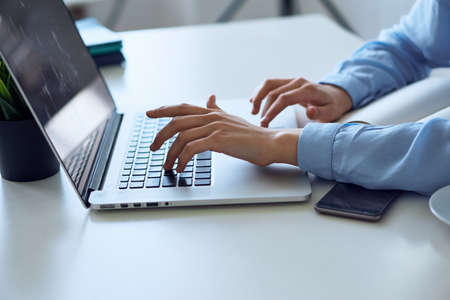 Business woman working behind laptop, business woman typing, phone, laptop, work.の写真素材