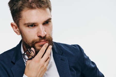 Businessman with a beard holding glasses on white isolated background, emotions.picture, office, work.の写真素材