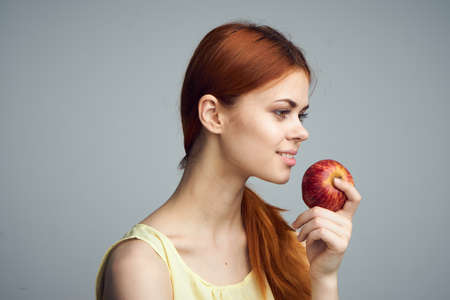 Fruit, summer, nutrition, food, girl on a gray background holds an apple, beauty, health.の写真素材