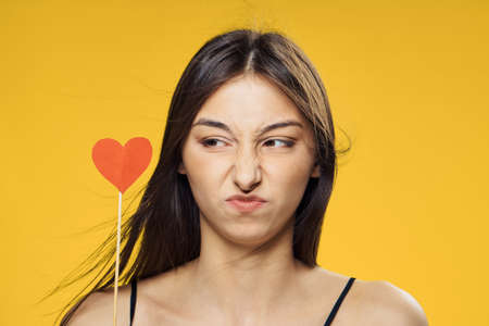 Paper accessories for parties and celebrations, emotions, woman on a yellow background, brunette.の写真素材