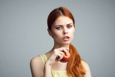 Fruit, summer, nutrition, food, girl on a gray background holds an apple, beauty, health.の写真素材