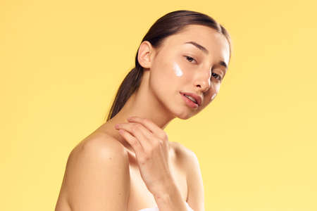 Beauty, health, face cream, woman on a yellow background.の写真素材