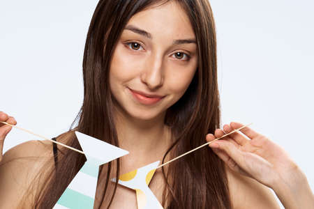 Paper accessories for parties and celebrations, brunette, portrait, woman on white isolated background.の写真素材