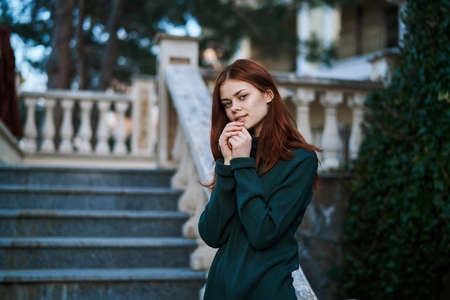 Red-haired woman standing in the street wearing a sweater, beautiful girl, architecture.の写真素材