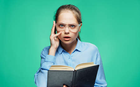 Woman with glasses, woman with a notepad, woman on a green background.の写真素材