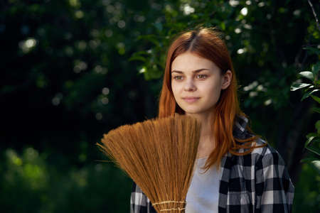 Woman with broom, broom, summer cottage, summer, woman at the cottage, garden.の写真素材