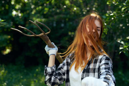 Woman with a pitchfork, gardener, summer cottage, summer residence, summer, season, woman in the garden.の写真素材