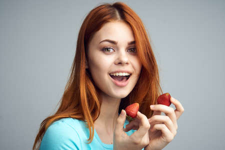 Woman with strawberry, joyful woman, sweet strawberry, strawberry, woman on gray background.の写真素材