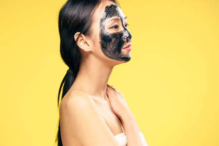 Woman in a cosmetic mask, facial, woman on a yellow background.の写真素材