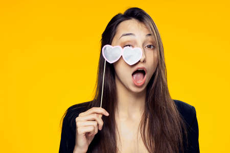 Holiday, woman with glasses on stick, woman with glasses, woman on yellow background portrait.の写真素材