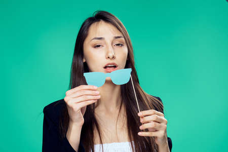 Paper accessories for parties and celebrations, woman on a green background.の写真素材