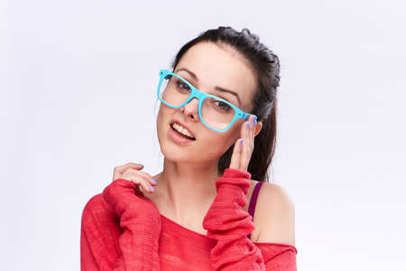 Young woman in blue glasses on white isolated background, portrait, emotions.の写真素材