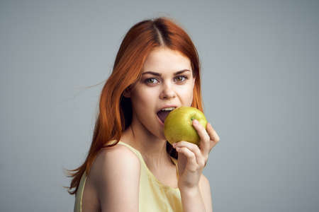 Healthy food, fruit, food, woman on a gray background holding an apple.の写真素材