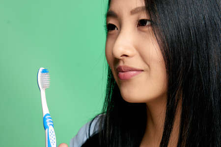 Asian, cleanliness of teeth, toothbrush, woman on green background.の写真素材