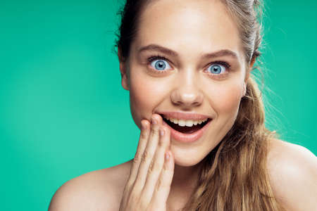Portrait, emotion, young woman on a green background, joy, smile.の写真素材