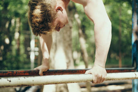 The sportsman is engaged on a horizontal bar in the street, sports.の写真素材