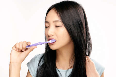 Asian, woman on white isolated background brushes teeth, toothbrush, dentistry.の写真素材