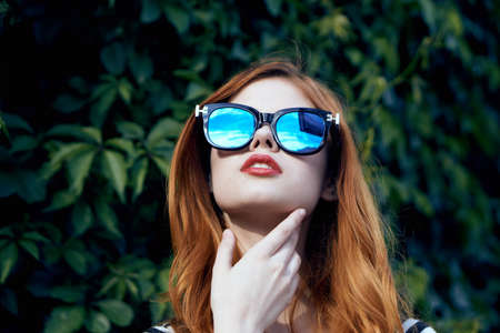 Fashion, style, young beautiful woman against nature background in sunglasses.の写真素材