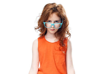 Little girl on white isolated background in blue glasses, child.の写真素材