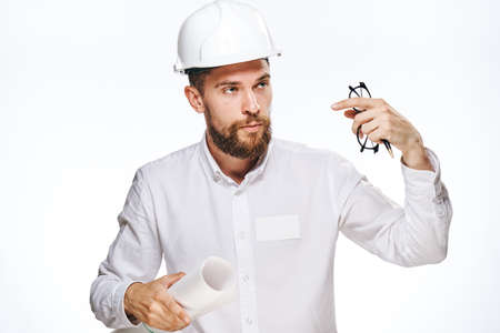 Engineer with a beard on a white isolated background holds a blueprint, builder.の写真素材