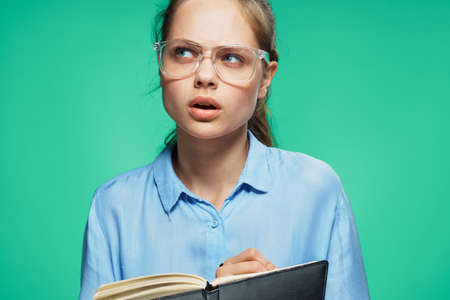 Young woman on a green background, student, teacher, emotions.