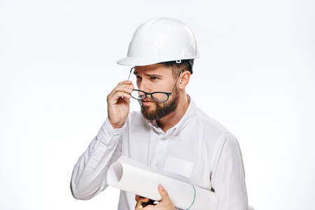 Engineer with a beard on a white isolated background holds a blueprint, builder.の写真素材