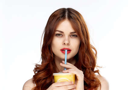 Beautiful young woman with red hair on white isolated background, soda, meal..