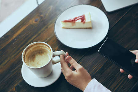 Young woman working at a computer in a cafe at breakfast.の写真素材