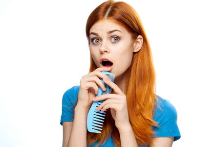 Young woman on white isolated background, hairbrush, hairstyle, haircut.の写真素材