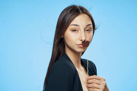 Woman on Blue background holds paper accessories for parties.の写真素材