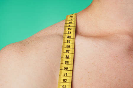 Measuring tape, man on a green background.の写真素材