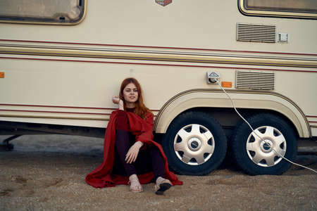 Beautiful young woman on the sand near the trailer, summer.の写真素材