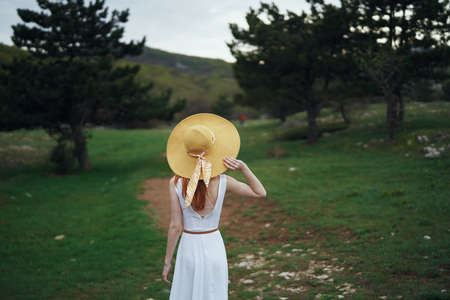 Beautiful young woman is walking in nature, in the forest, field.の写真素材