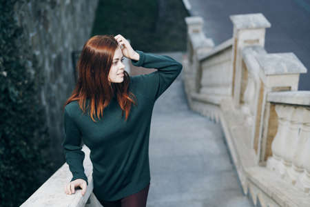 Beautiful young woman is walking along the street in the city.