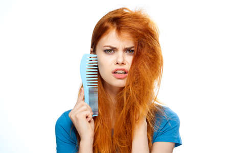 Beautiful young woman on white isolated background, comb, hairstyle.