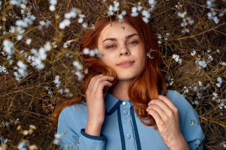 Beautiful young woman lies in a field of flowers.の写真素材