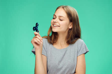 Beautiful young woman on a green background holds a spinner.