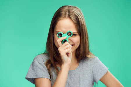 Beautiful young woman on a green background holds a spinner.の写真素材
