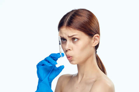 Young beautiful woman on white isolated background holds a syringe, medicine, nurse.