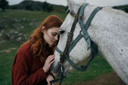 Beautiful young woman walking in the mountains with her horse.の写真素材