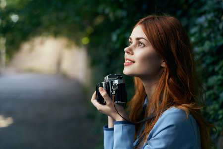 Beautiful young woman walking through the streets with a camera.の写真素材