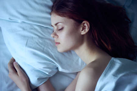 Beautiful young woman sleeping in her bed in the bedroom.の写真素材